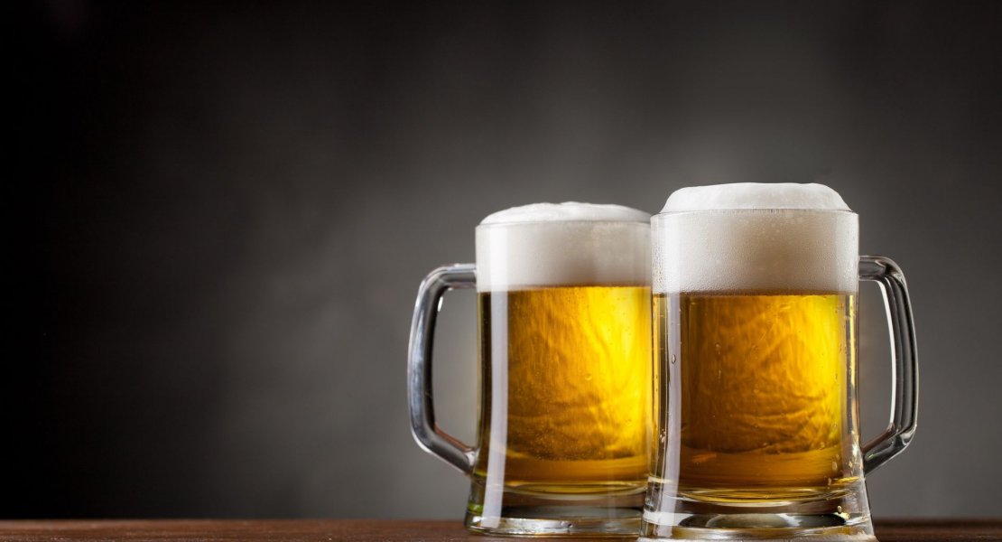 Two beer glasses with a dark background